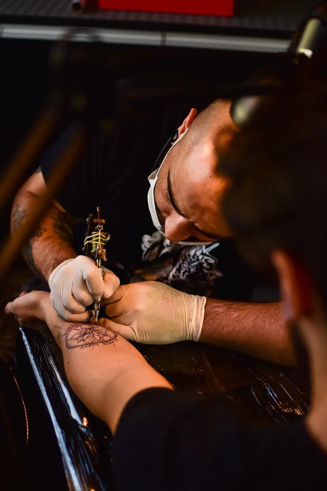 Tatuador trabajando en un brazo